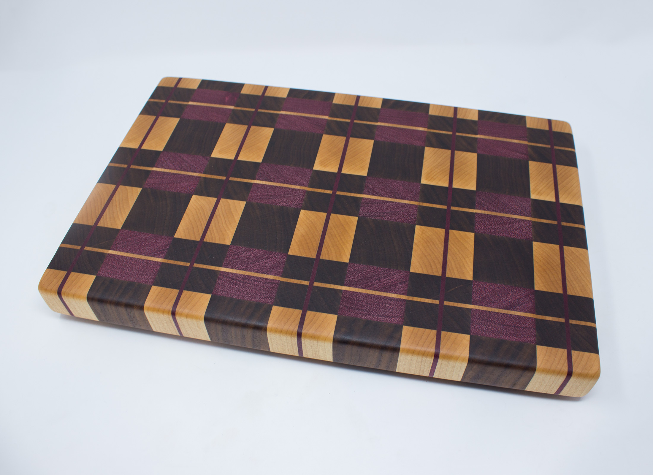 https://www.rockfordwoodcrafts.com/wp-content/uploads/Purple-Plaid-End-Graing-Cutting-Board-Top-Angled.jpg